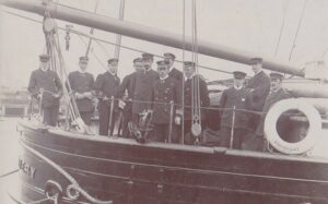 Reginald Koettlitz, just left of Scott, with Shackleton 2nd left. on the stern of the Discovery before departure
